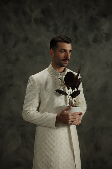 White sherwani for grooms with elegant embroidery, perfect for weddings.